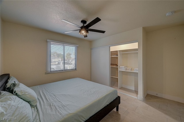 bedroom featuring ceiling fan, a textured ceiling, and a closet