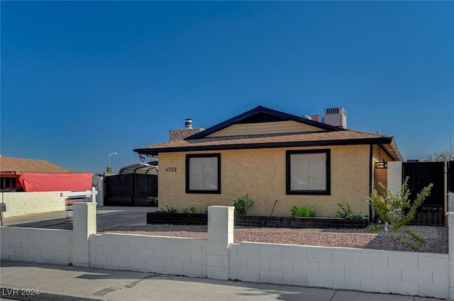 4729 Bennett Dr, Las Vegas, NV 89121 - view of front of property with stucco siding, fence, a gate, a chimney, and a shingled roof