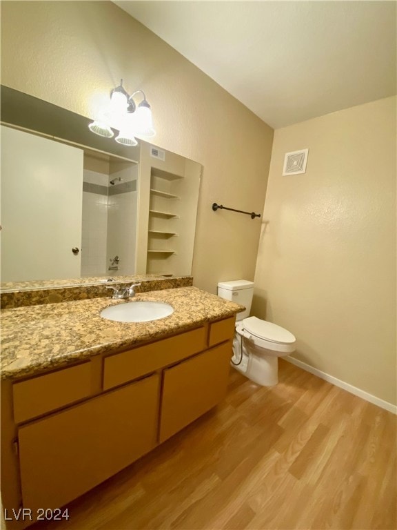 bathroom featuring vanity, toilet, hardwood / wood-style floors, and a shower