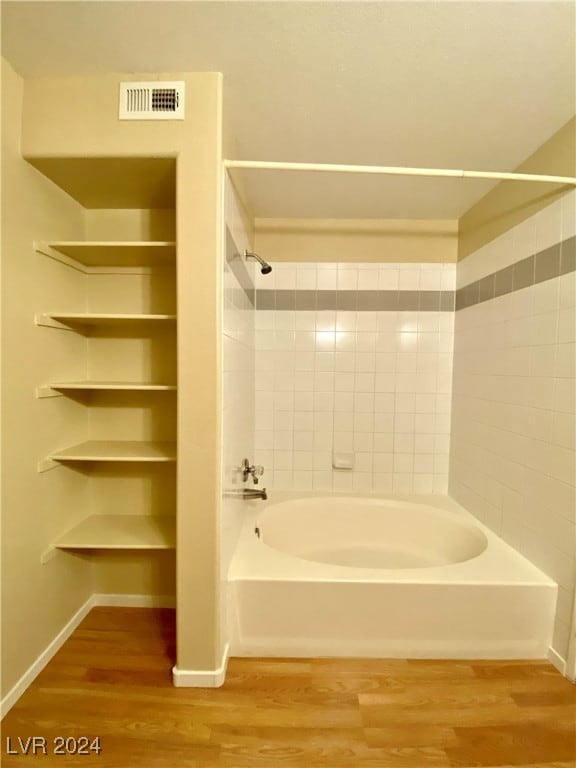 bathroom featuring tiled shower / bath and hardwood / wood-style floors