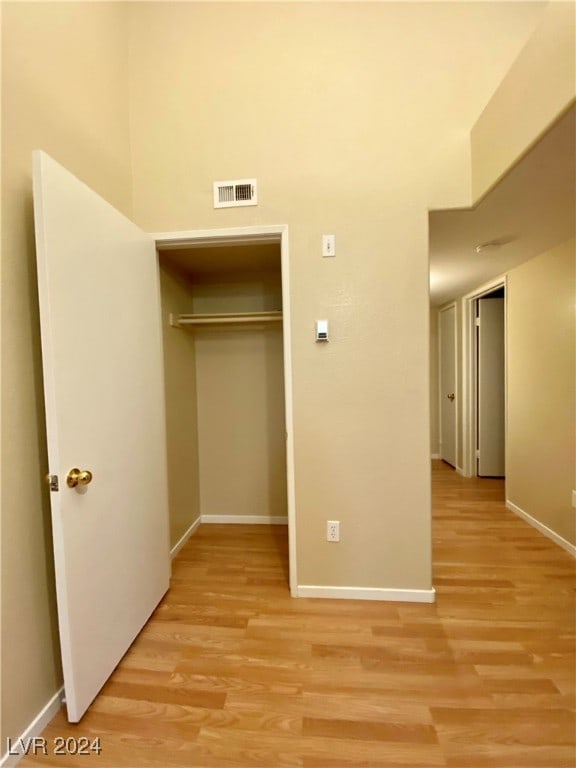 unfurnished bedroom featuring light hardwood / wood-style flooring and a closet