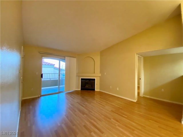 unfurnished living room with vaulted ceiling and hardwood / wood-style floors