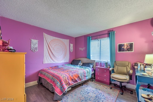 bedroom with a textured ceiling and hardwood / wood-style flooring
