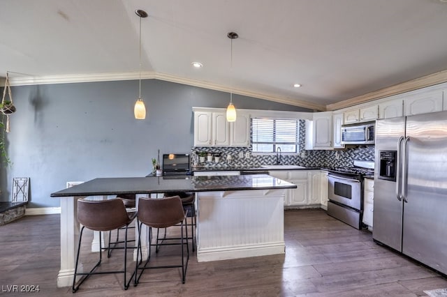 kitchen with white cabinetry, appliances with stainless steel finishes, a kitchen island, and vaulted ceiling