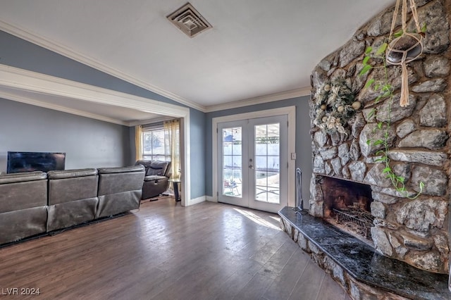 living room with ornamental molding, french doors, a stone fireplace, hardwood / wood-style flooring, and vaulted ceiling