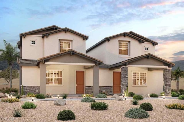 view of front of home featuring stone siding and stucco siding