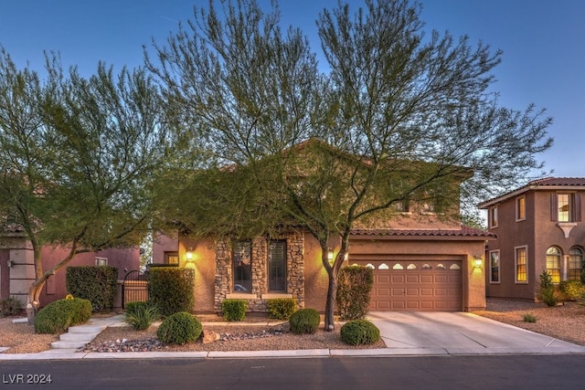 view of front facade featuring a gate, fence, driveway, stucco siding, and stone siding