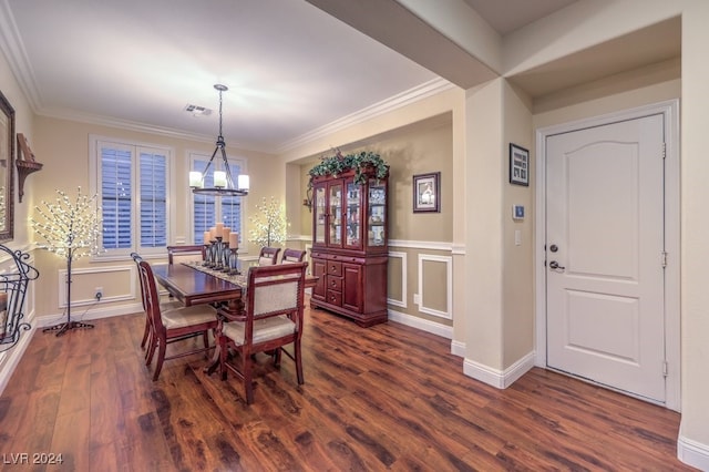 dining room with dark wood-type flooring, ornamental molding, and a notable chandelier