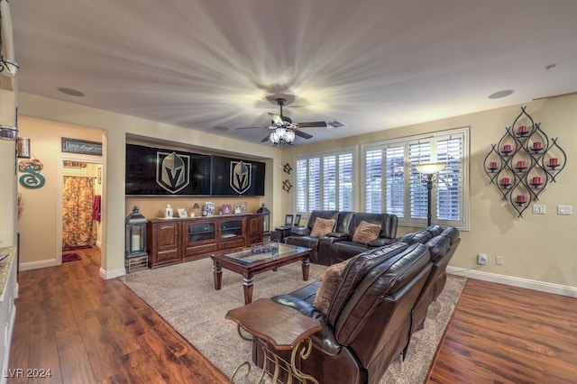 living area featuring visible vents, a ceiling fan, dark wood-style flooring, and baseboards