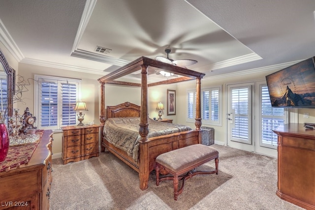 carpeted bedroom with visible vents, a raised ceiling, access to exterior, and ornamental molding