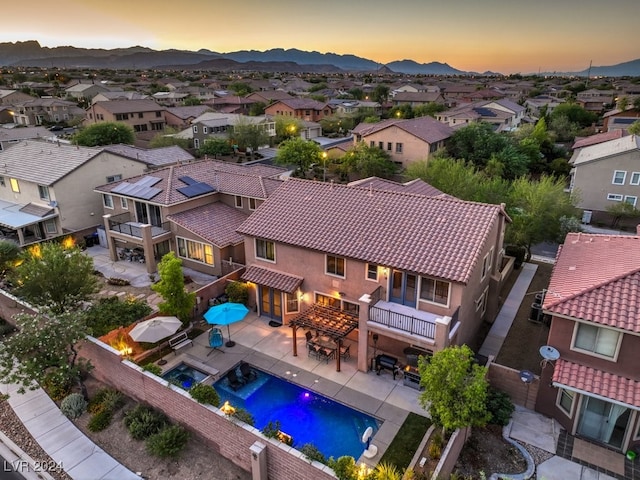 aerial view at dusk featuring a mountain view and a residential view