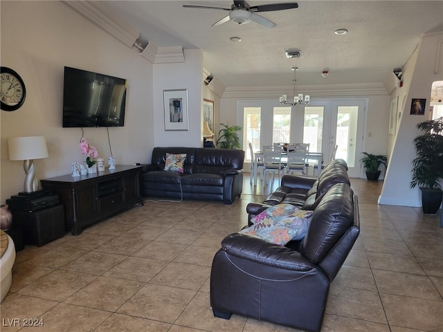 tiled living room with ceiling fan with notable chandelier, a textured ceiling, and ornamental molding