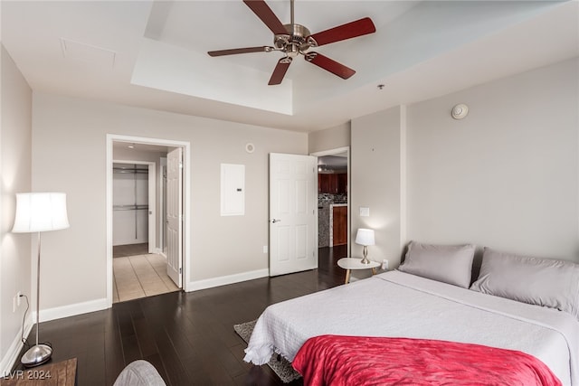 bedroom featuring a spacious closet, a closet, hardwood / wood-style floors, electric panel, and ceiling fan