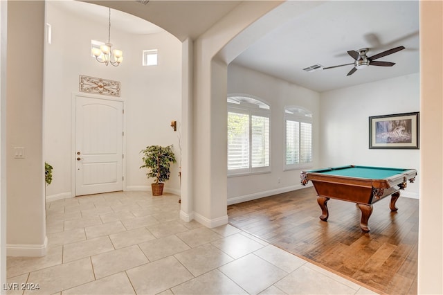 game room featuring plenty of natural light, pool table, ceiling fan with notable chandelier, and light hardwood / wood-style floors