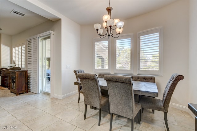 tiled dining space with a healthy amount of sunlight and a notable chandelier