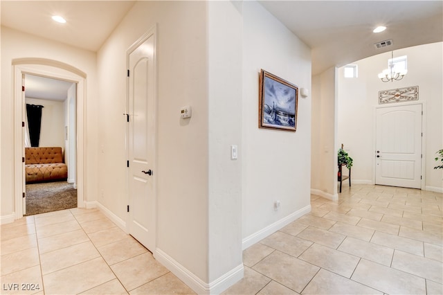 tiled entrance foyer with an inviting chandelier