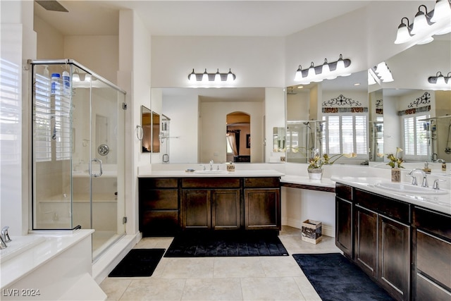 bathroom with plus walk in shower, tile patterned flooring, ceiling fan, and vanity