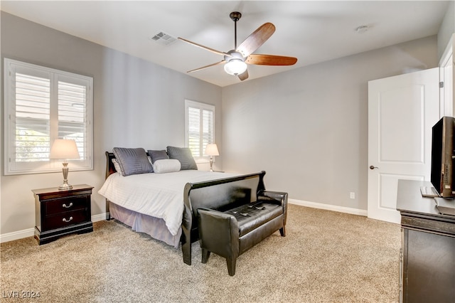 carpeted bedroom with multiple windows and ceiling fan