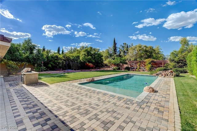 view of swimming pool with a lawn and a patio area