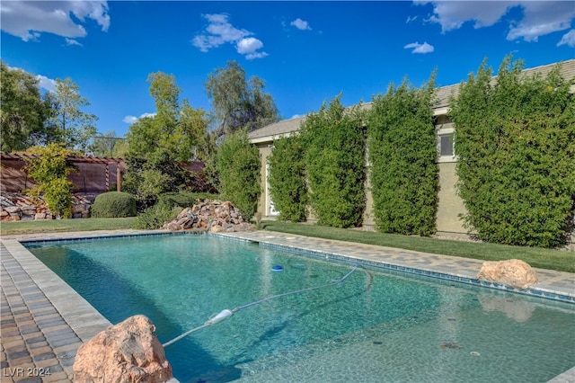 view of swimming pool featuring a yard