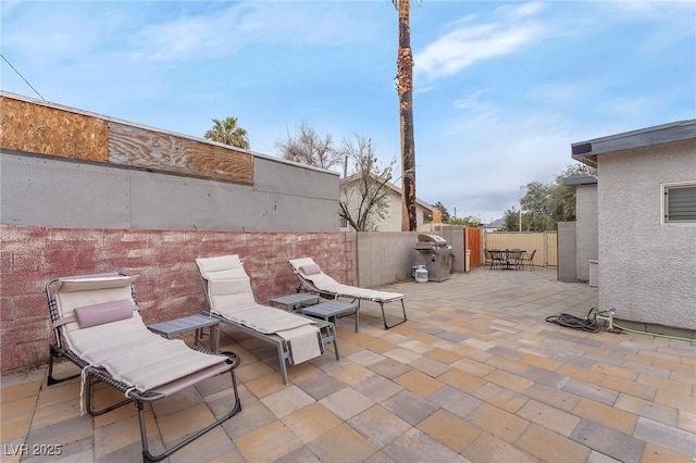 view of patio featuring area for grilling and fence