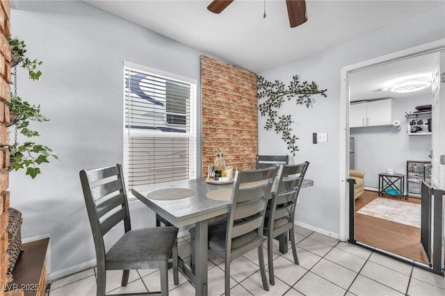 dining room featuring light tile patterned floors, a ceiling fan, and baseboards