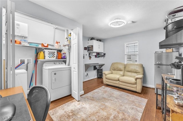 office space with a textured ceiling, washing machine and clothes dryer, and wood finished floors