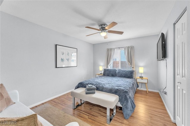 bedroom featuring light wood-type flooring, baseboards, and a ceiling fan