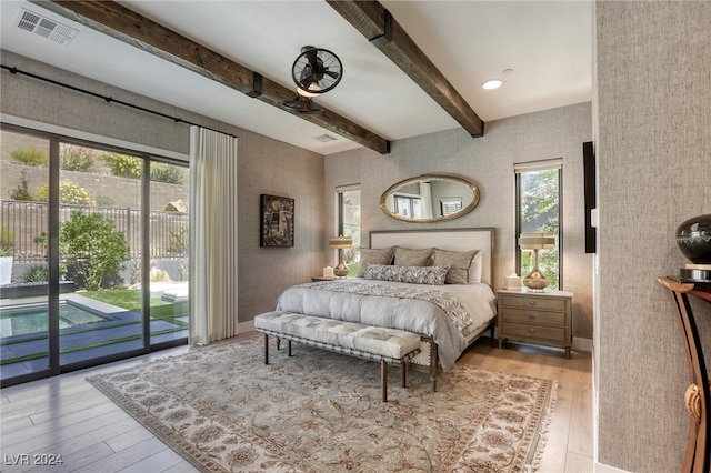 bedroom with light wood-type flooring, multiple windows, and beamed ceiling