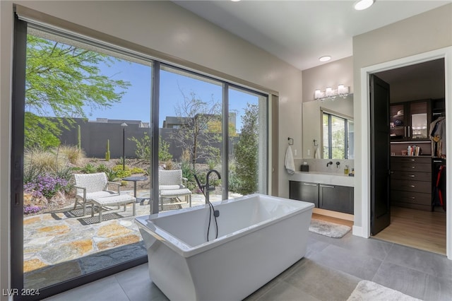 bathroom with vanity, plenty of natural light, wood-type flooring, and a bathtub