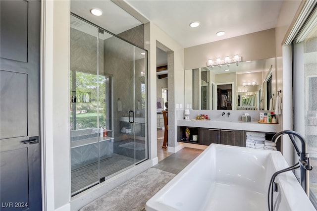 bathroom with vanity and shower with separate bathtub