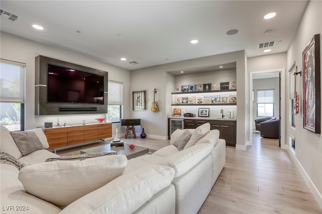 living room with light hardwood / wood-style flooring and beverage cooler