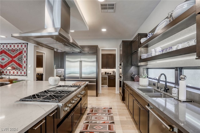 kitchen featuring light hardwood / wood-style flooring, island range hood, stainless steel appliances, sink, and light stone counters