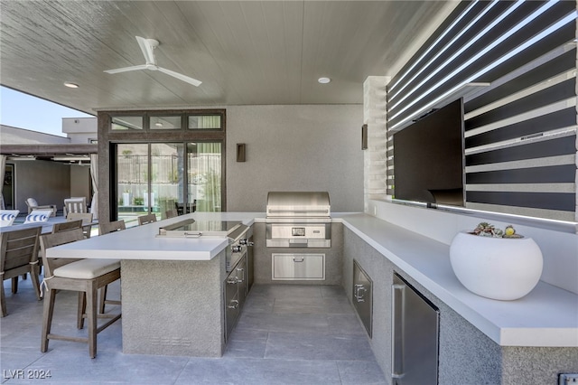 view of patio / terrace with a grill, ceiling fan, and an outdoor kitchen