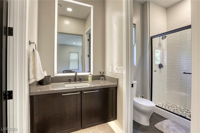 bathroom with tile patterned flooring, vanity, toilet, and a shower with door