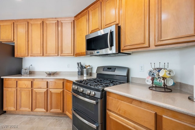 kitchen featuring stainless steel appliances and light tile patterned floors