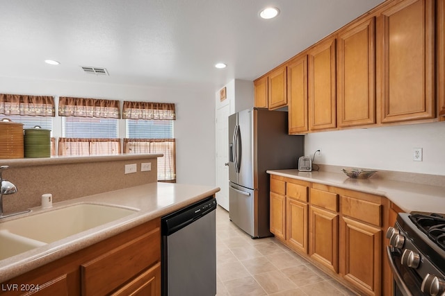 kitchen featuring sink, appliances with stainless steel finishes, and light tile patterned flooring