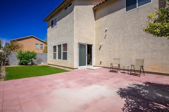 back of house with a patio area and a yard