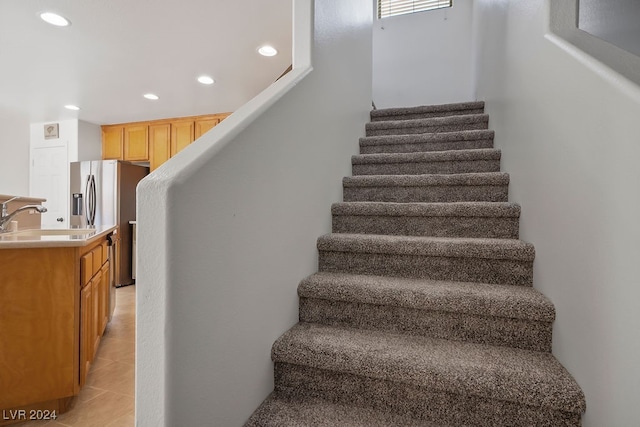 stairs featuring sink and tile patterned flooring