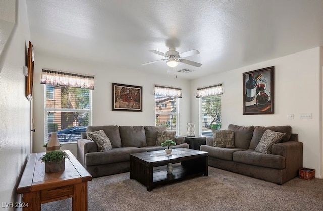 carpeted living room featuring a textured ceiling and ceiling fan