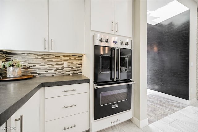 kitchen with double oven, backsplash, and white cabinets