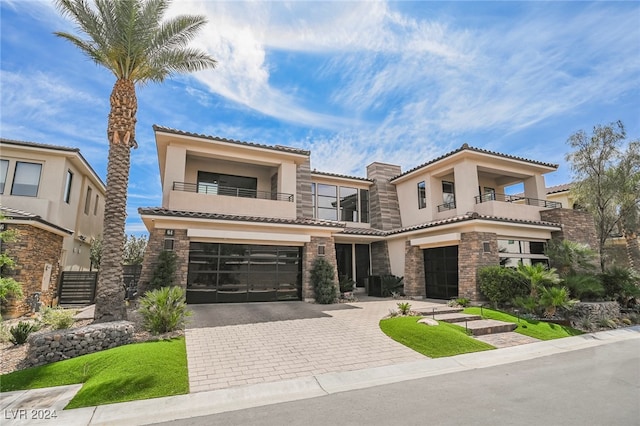 mediterranean / spanish-style home with a garage and a balcony