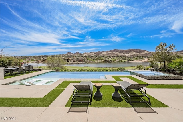 view of swimming pool with a water and mountain view, an in ground hot tub, and a patio area