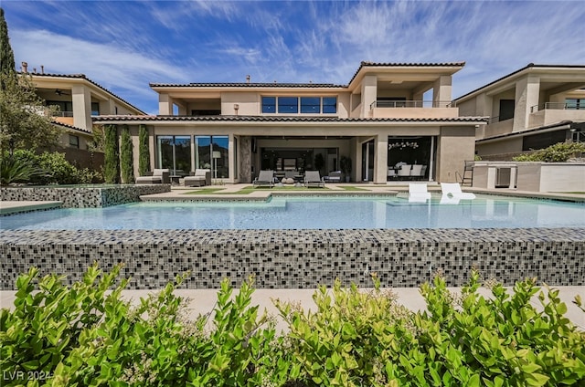 rear view of property featuring a balcony and a patio area