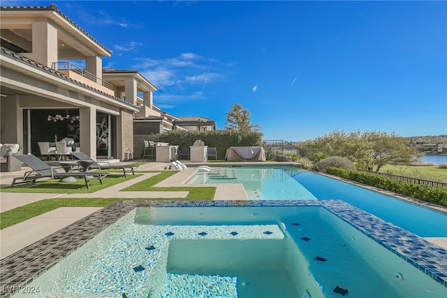 view of swimming pool featuring a patio and an in ground hot tub