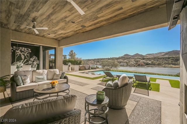 view of patio featuring outdoor lounge area, a water and mountain view, and ceiling fan