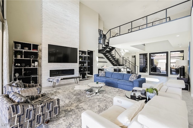 living room with a towering ceiling and a fireplace