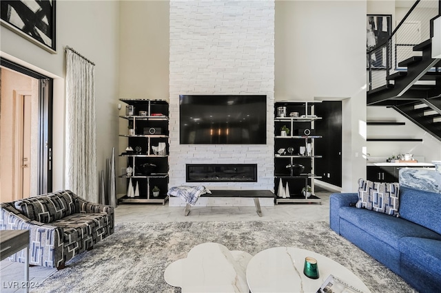 living room featuring a fireplace and a high ceiling