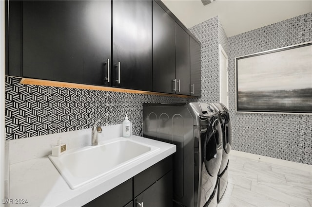 washroom featuring cabinets, separate washer and dryer, and sink