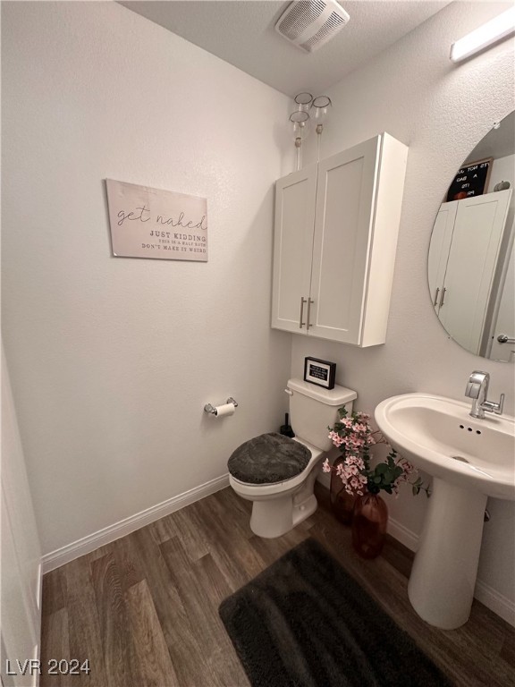 bathroom featuring wood-type flooring and toilet